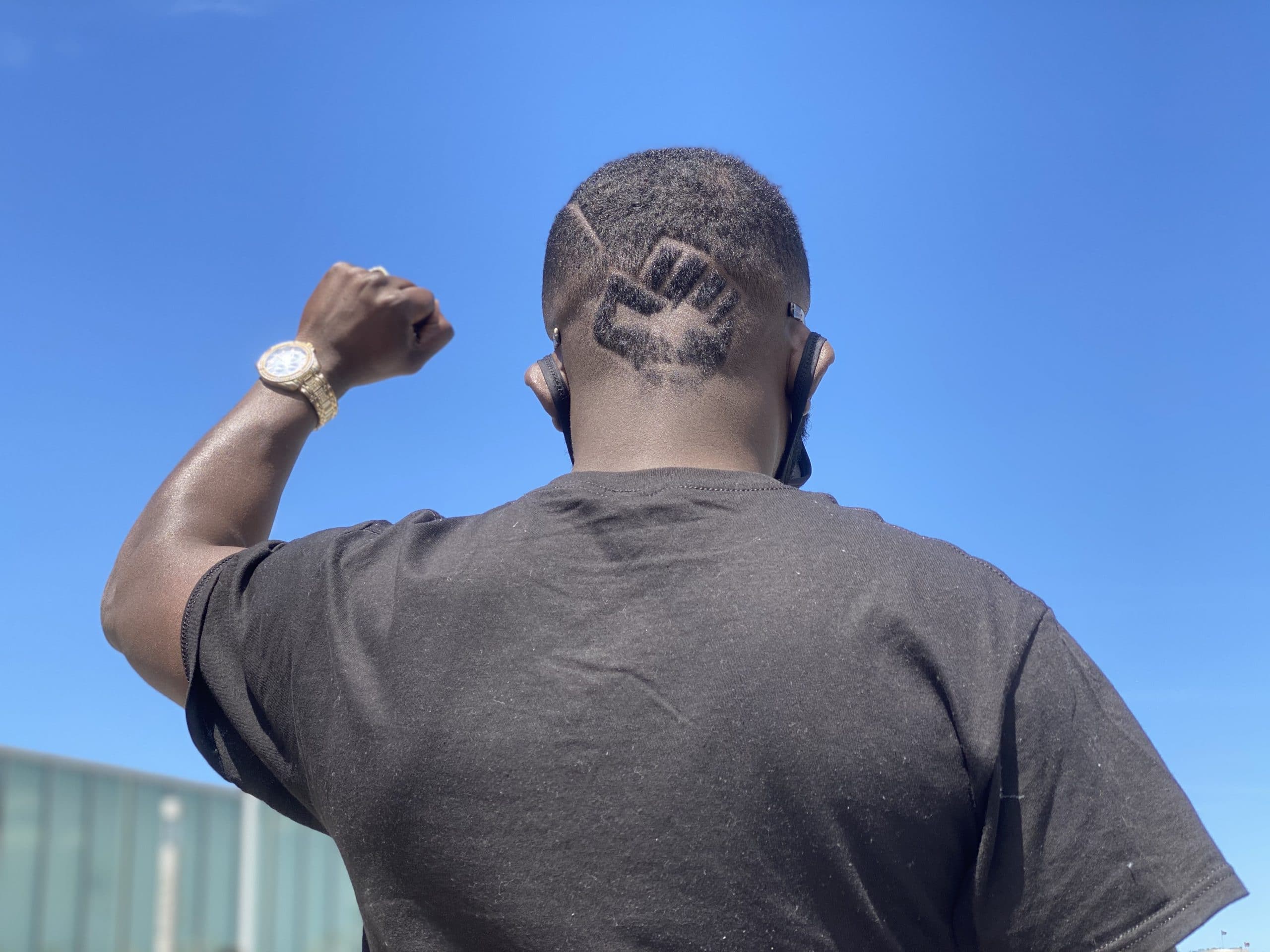A man holding his fist in the air during a Black Lives Matter rally